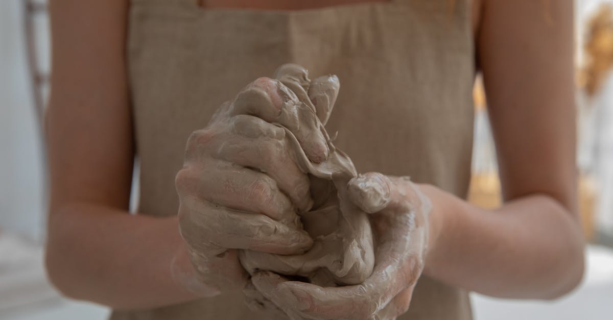 12-hour fermentation makes dough wetter - Crop faceless woman kneading clay in workshop