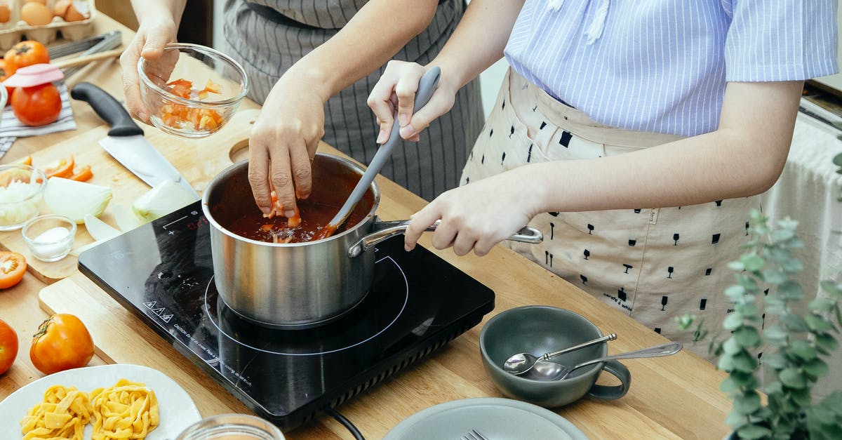 'Caramelization' of tomato sauce in slow cooker - Crop women cooking sauce in kitchen