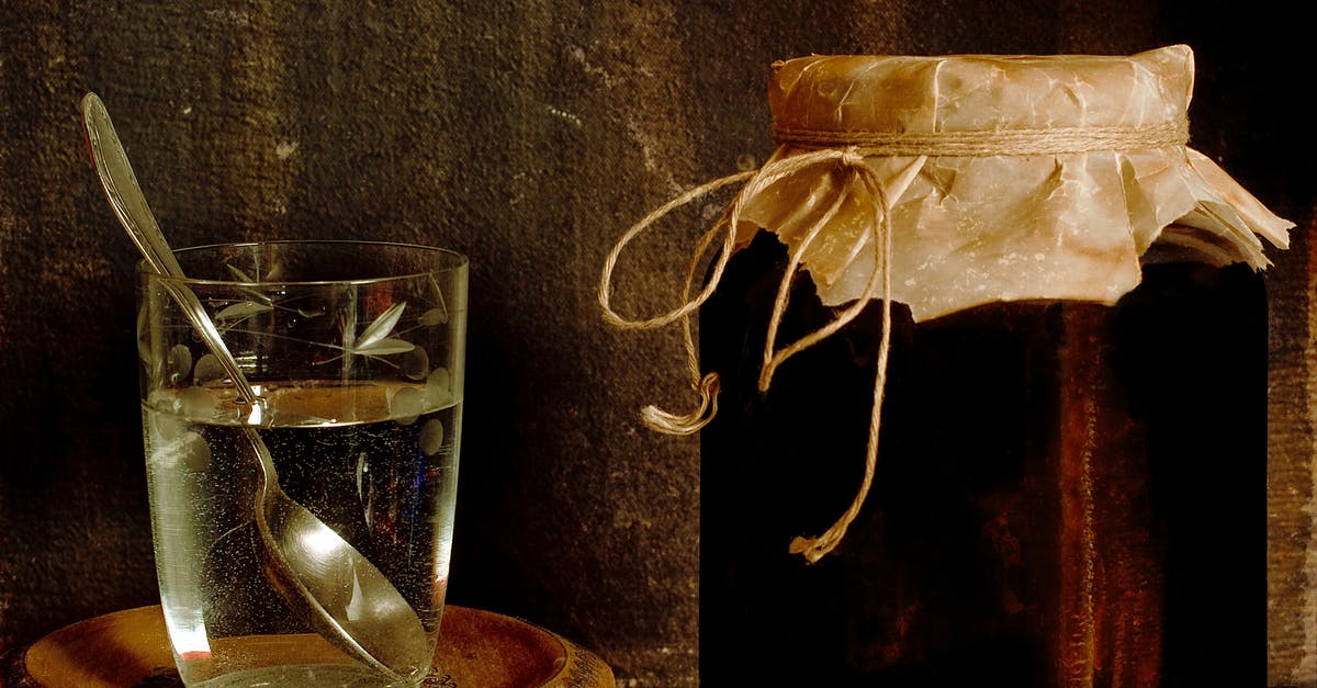 'Sweet milk' substitute in an old recipe - Jar with homemade jam placed with glass of water on shabby table in rural house