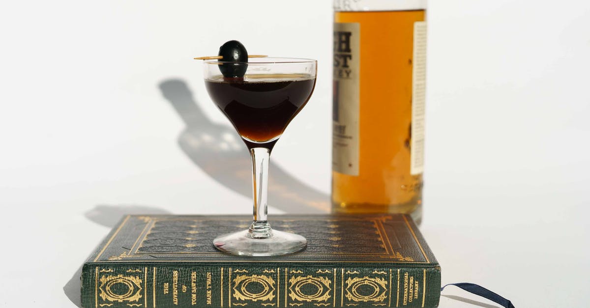 A great book with recipes for Tapas - Martini cocktail on book near bottle of whiskey