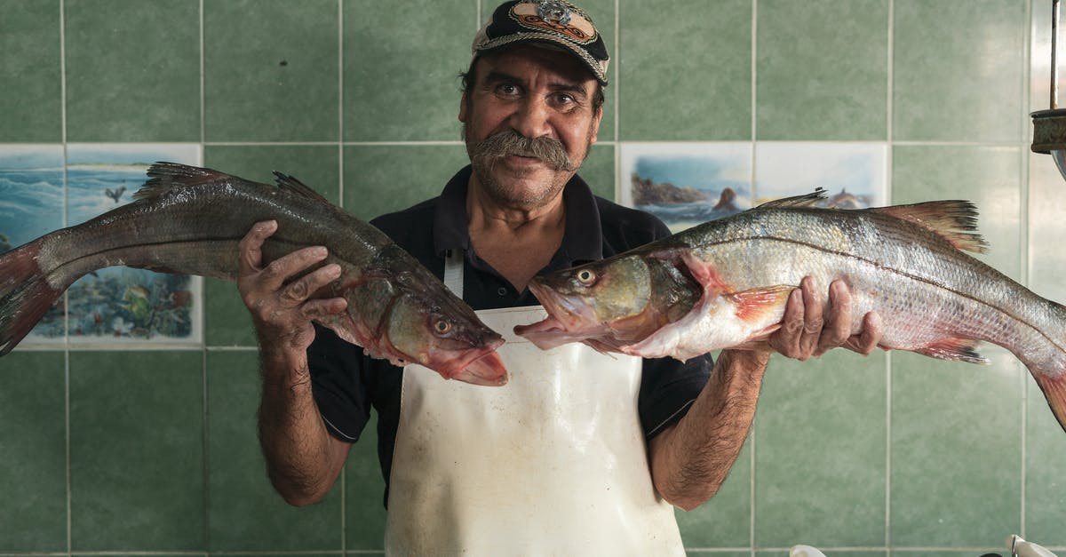 A question of Fishmonger basics and fish processing and handling? - Fishmonger Holding Two Fish