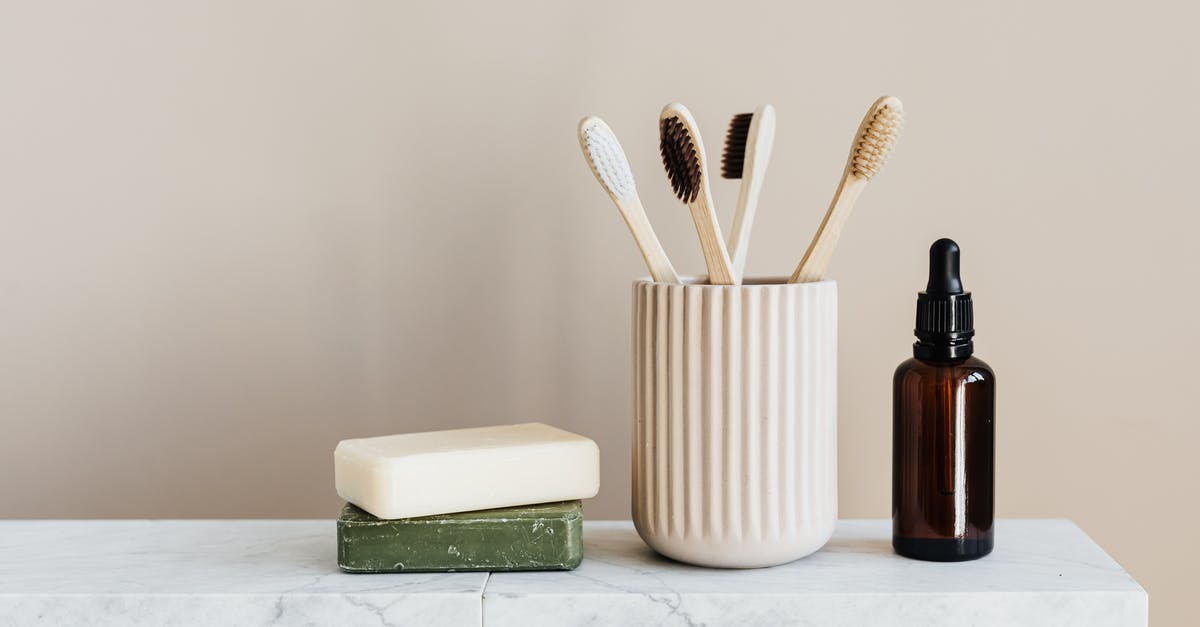 A vegan alternative to Quorn? - Collection of organic soaps and bamboo toothbrushes in ceramic minimalism style holder placed near renewable glass bottle with essential oil on white marble tabletop against beige wall