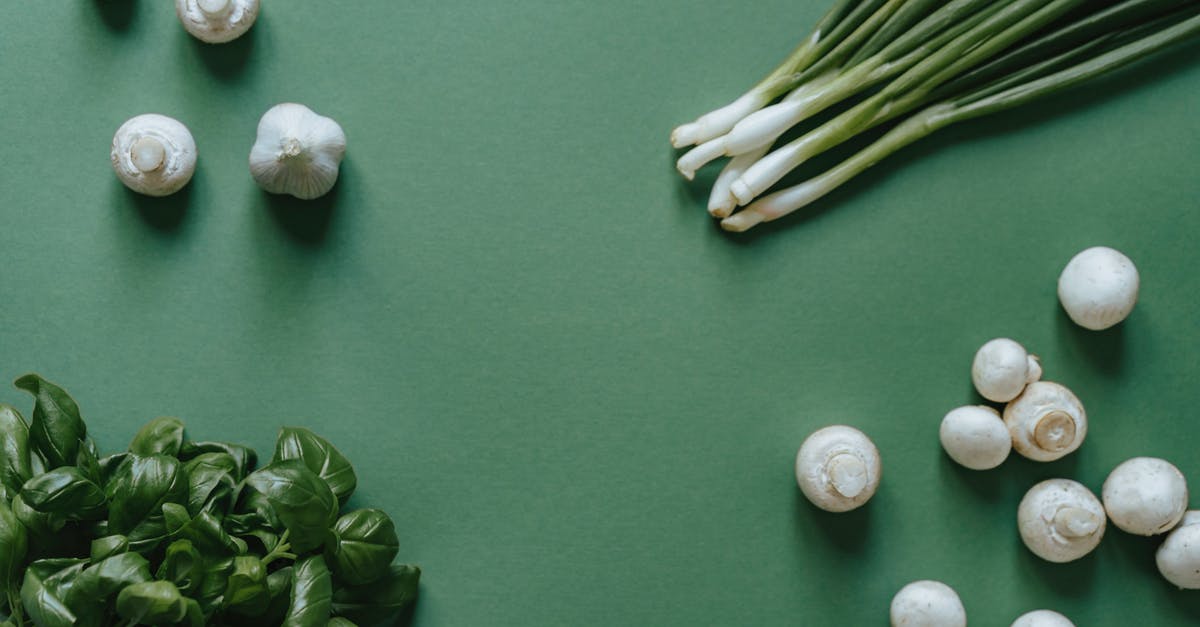 Accentuating Garlic flavour - White and Green Round Fruits on Green Textile