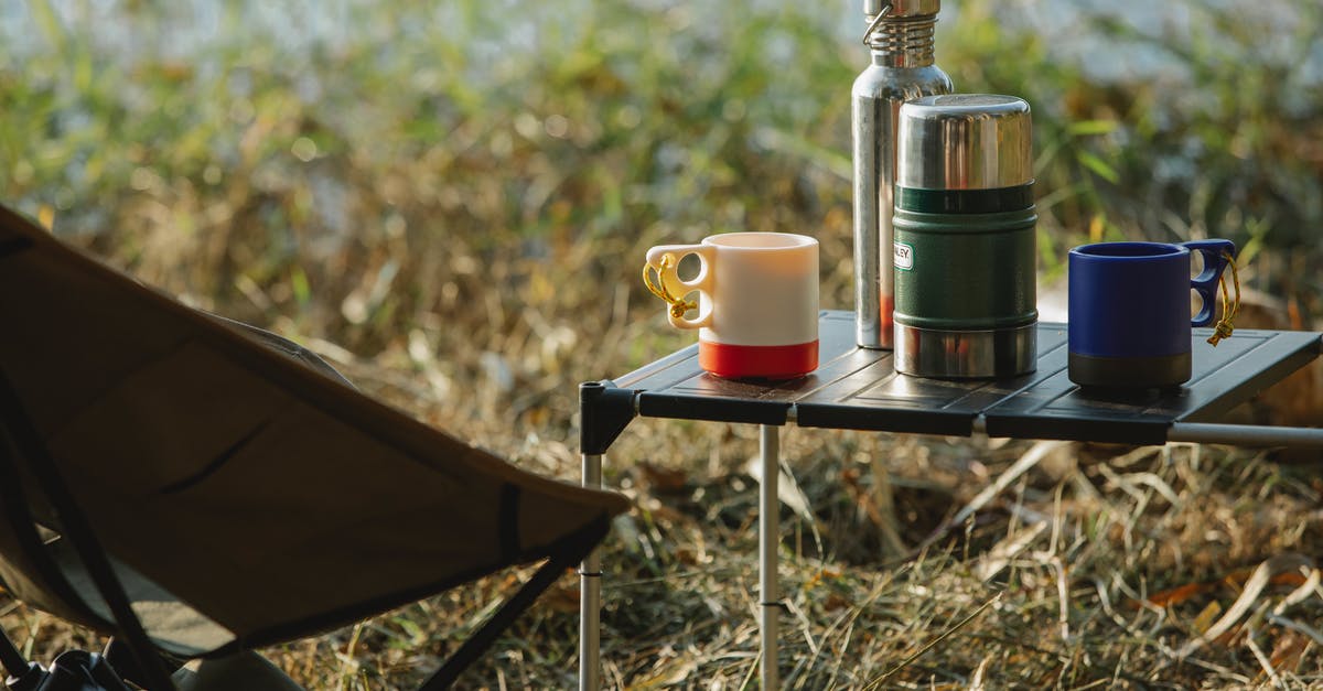 Accidentally microwaved stainless steel travel coffee mug. Still safe to use? - Stainless steel vacuum flasks and mugs with hot drinks on portable table near folding chair on grass shore