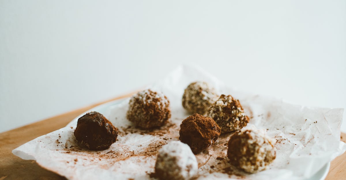 Achieving viscosity when making cocoa spread, without butter or coconut oil, with colza oil, without nuts - Chocolate Balls on Baking Paper on White Ceramic Plate