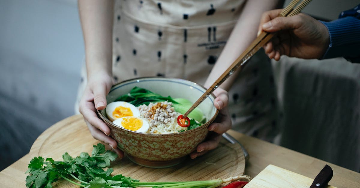 Add gelatin to soup as a replacement for stock? - Crop unrecognizable women decorating noodles soup with cut chili pepper