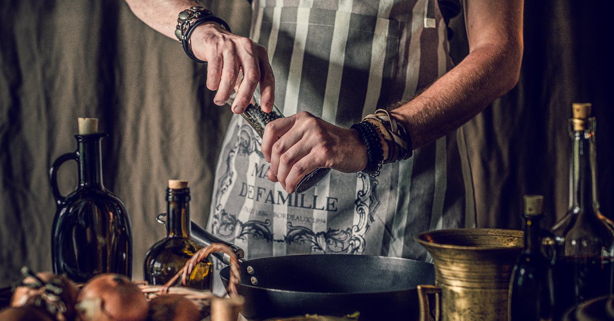 Add spice then oil, or oil then spice? - Crop cook using pepper mill while preparing healthy food in kitchen