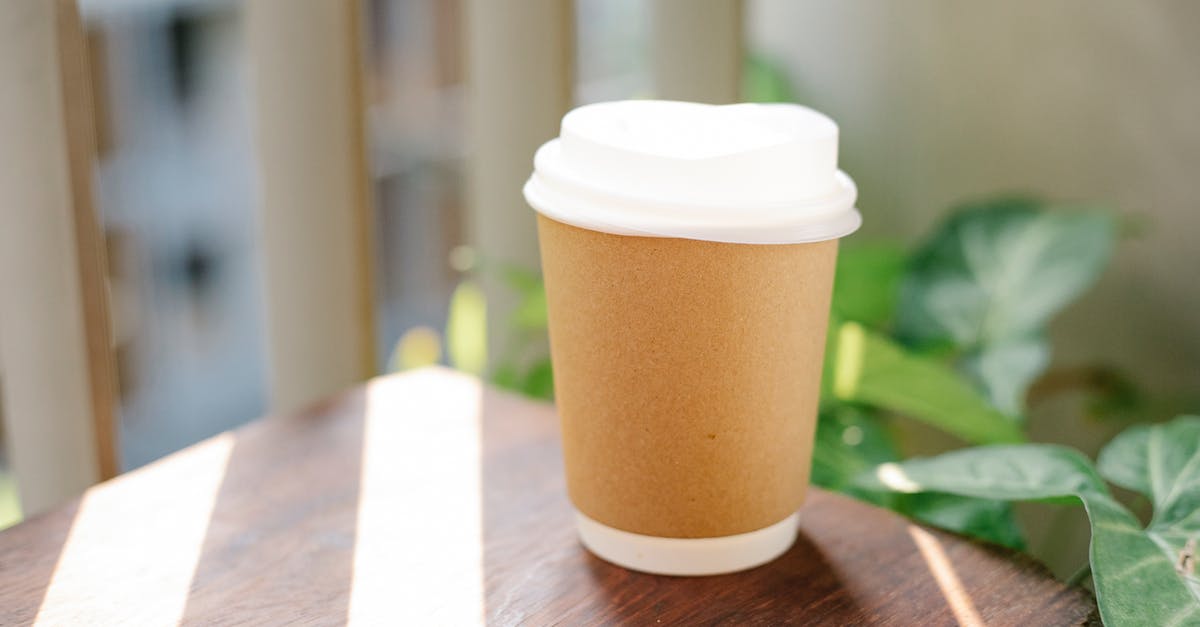 Adding cayene early makes it less hot - Paper cup of coffee to go placed on table in cafeteria in sunny morning