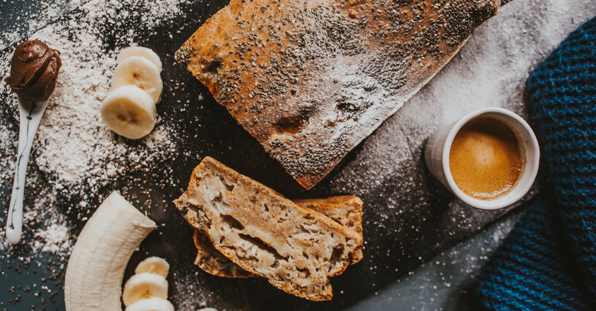 Adding fresh fruit to a non fruited banana bread - From above of appetizing cake topped with poppy seeds placed near cup of coffee and cut banana served on scattered with icing sugar chopping board on table