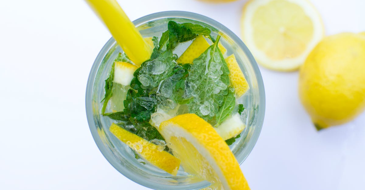 Adding lime juice to green curry paste and heating - Flat Lay Photograph of Highball Glass With Sliced Lemon