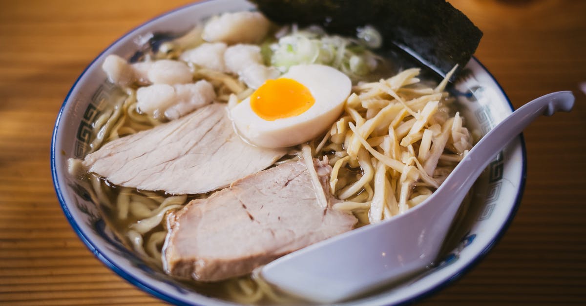 Adding Noodles to Soup - White Scoop on White Ceramic Bowl