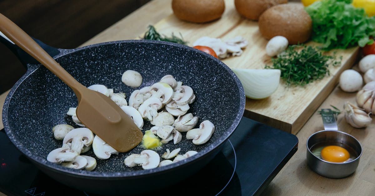 adding peanut butter to a recipe - Chopped mushrooms in frying pan placed on stove near various veggies and herbs