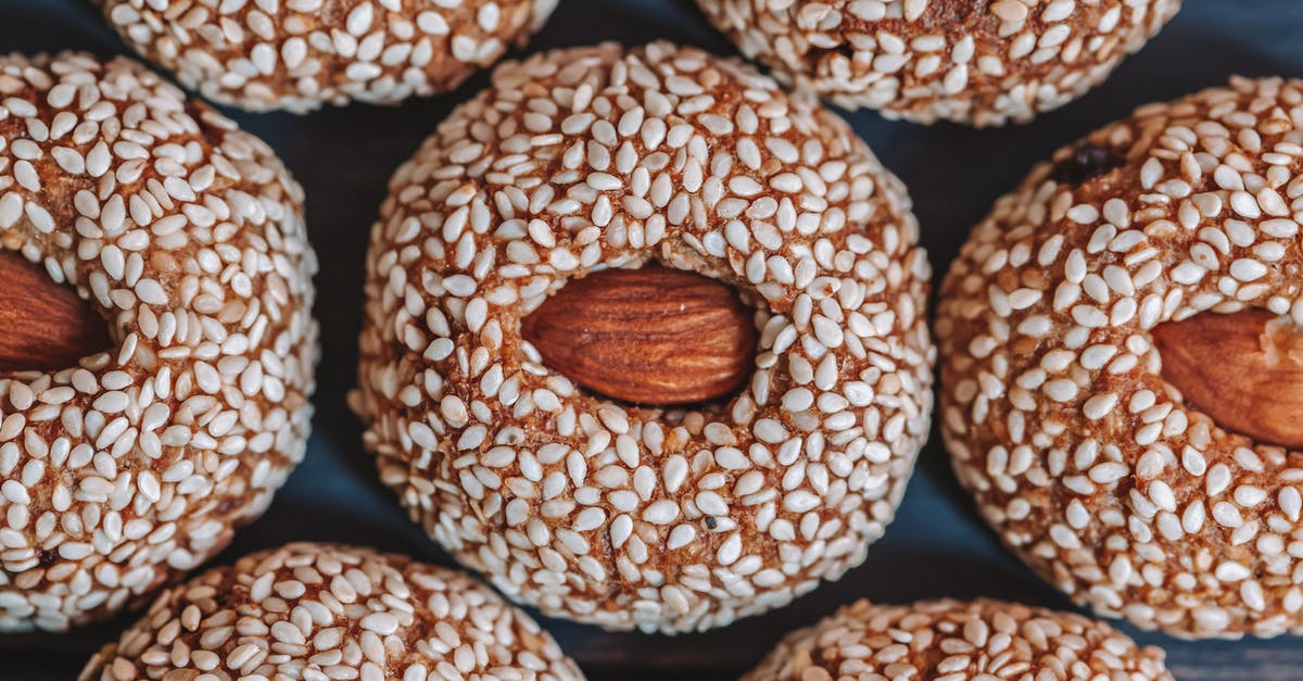 Adding raw chia seeds to baked goods? - Top view of background representing tasty biscuits with whole almonds in center and sesame seeds on top