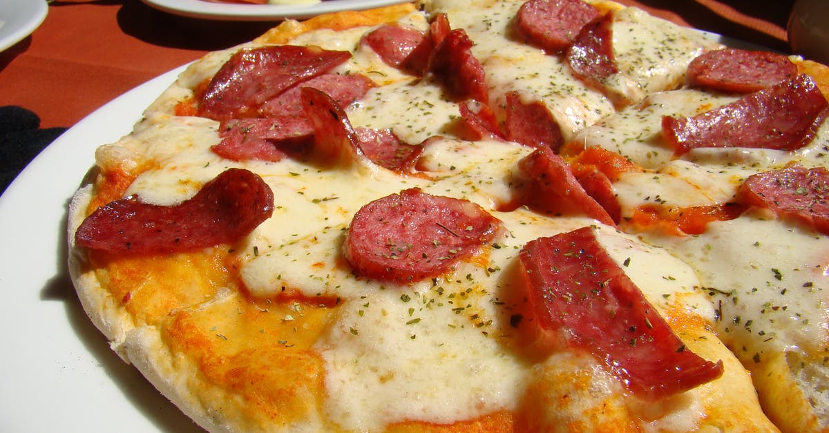 Adding tomatoes to pizza dough - Baked Pepperoni Pizza