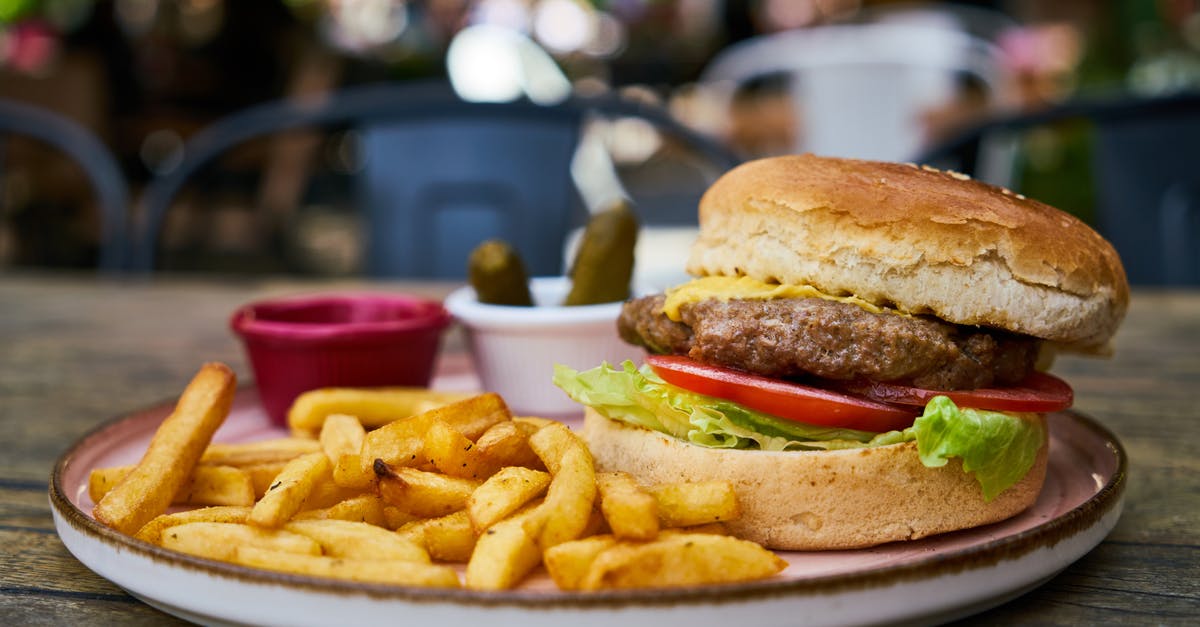 Adding water to a pan-fried burger - Burger and Fries on White Plate