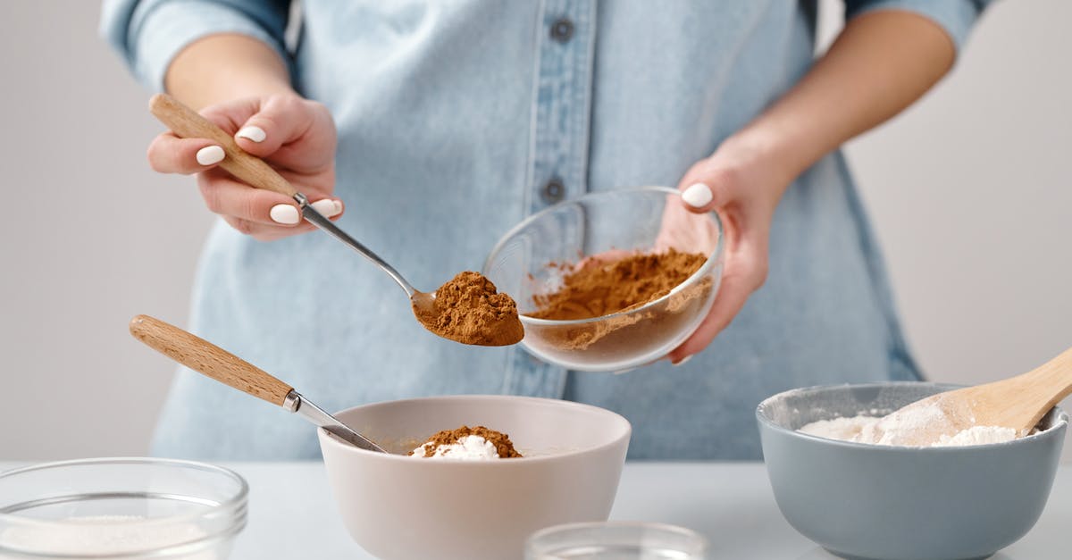 Adding xanthin gum to regular flour containing gluten - Person Adding a Spoon of Cinnamon in a Bowl
