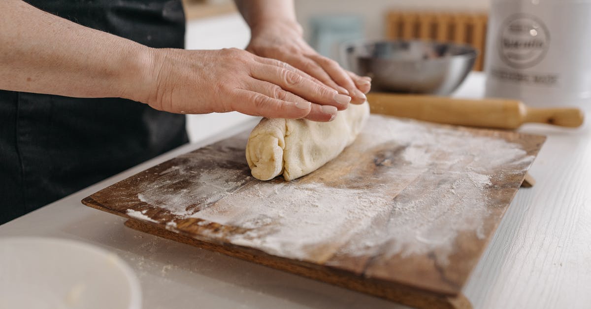 Additional flour threshold: when and how to perform? - Person Holding Dough on Brown Wooden Table