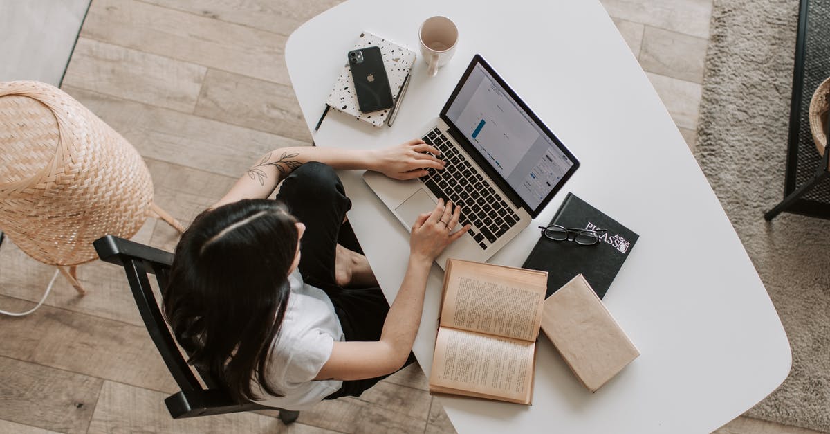 Advantages of using a non-glass teapot? - Young lady typing on keyboard of laptop in living room