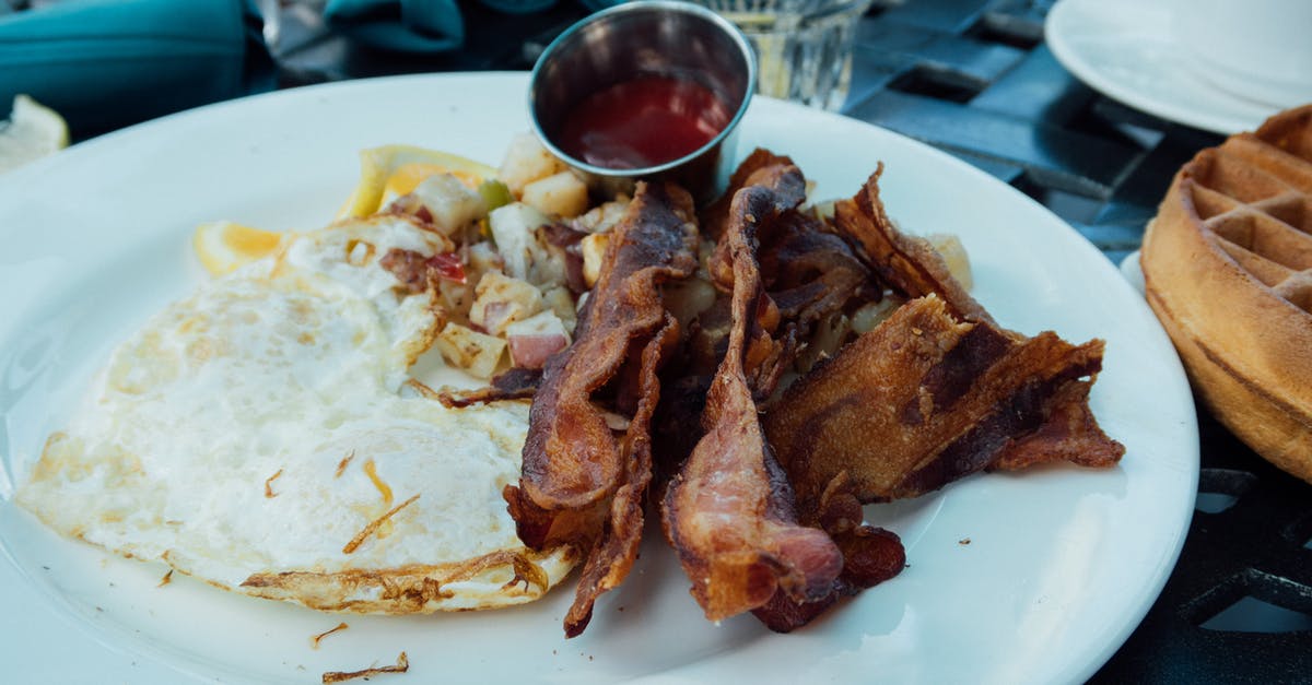 After breakfast, egg plate clean up - Bacon Strips and Sunny Side-up Egg Dish on Round White Ceramic Plate