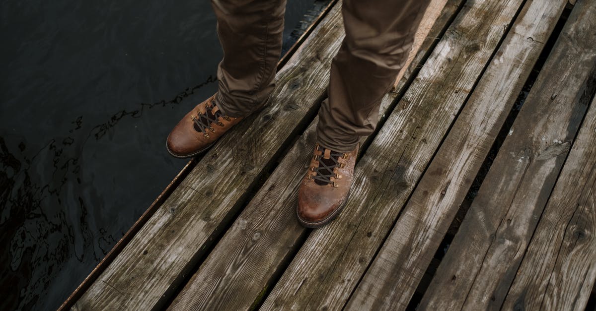 after re-hydrating and desalinating a salted cod it became slightly brown - Person in Brown Leather Boots Standing on Brown Wooden Dock