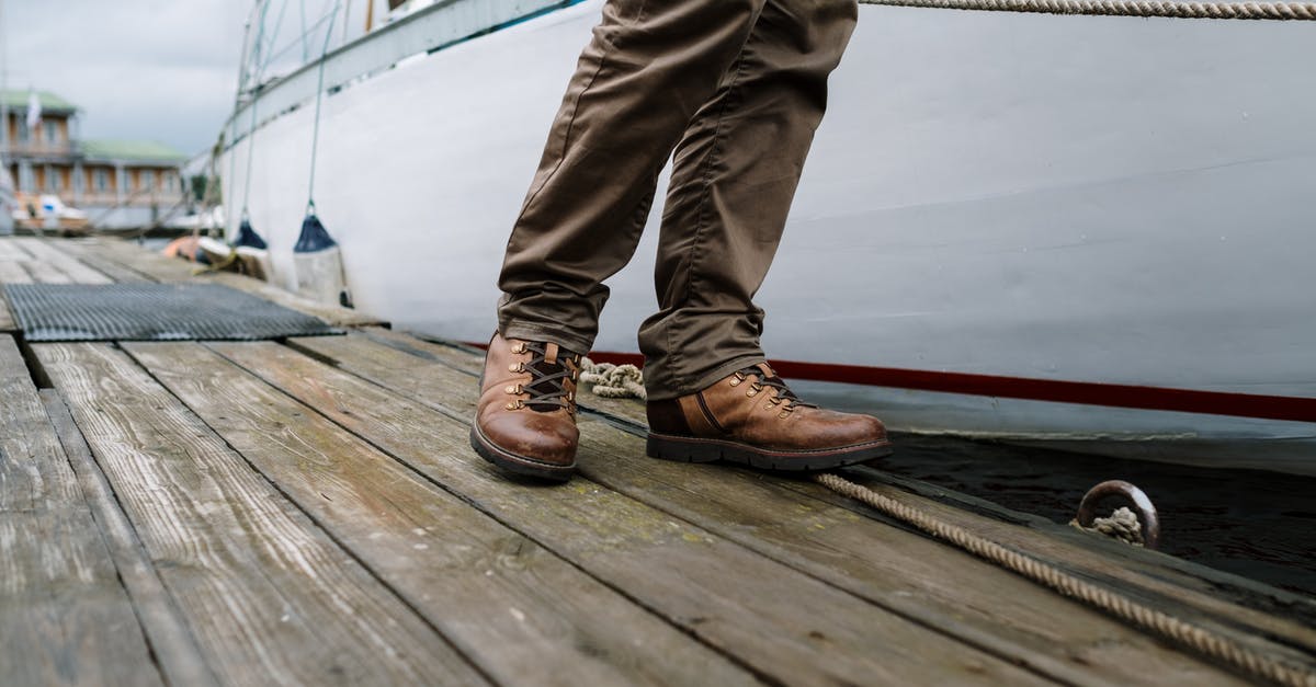 after re-hydrating and desalinating a salted cod it became slightly brown - Person in Brown Leather Boots Standing on Brown Wooden Dock