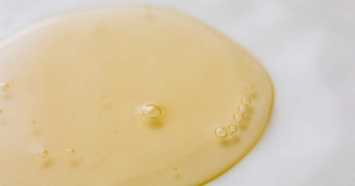 Air bubble on surface of chocolate - Transparent yellowish liquid on white surface