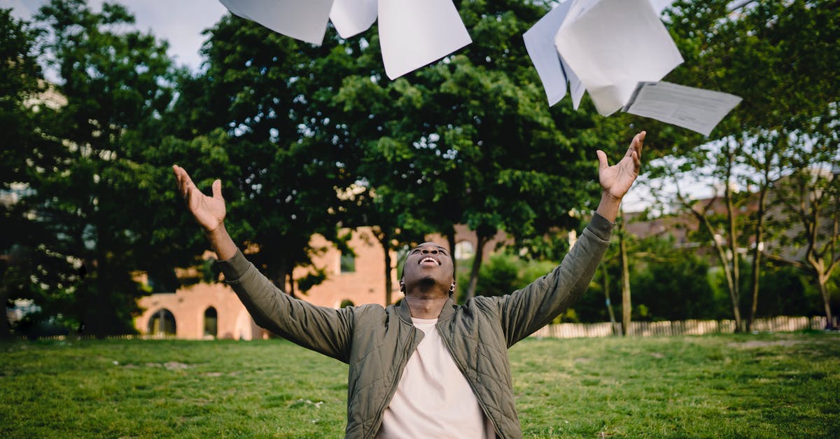 Air fried sweet potatoes have black dots on them - Happy young African American male student in casual outfit tossing university papers in air while having fun in green park after successfully completing academic assignments