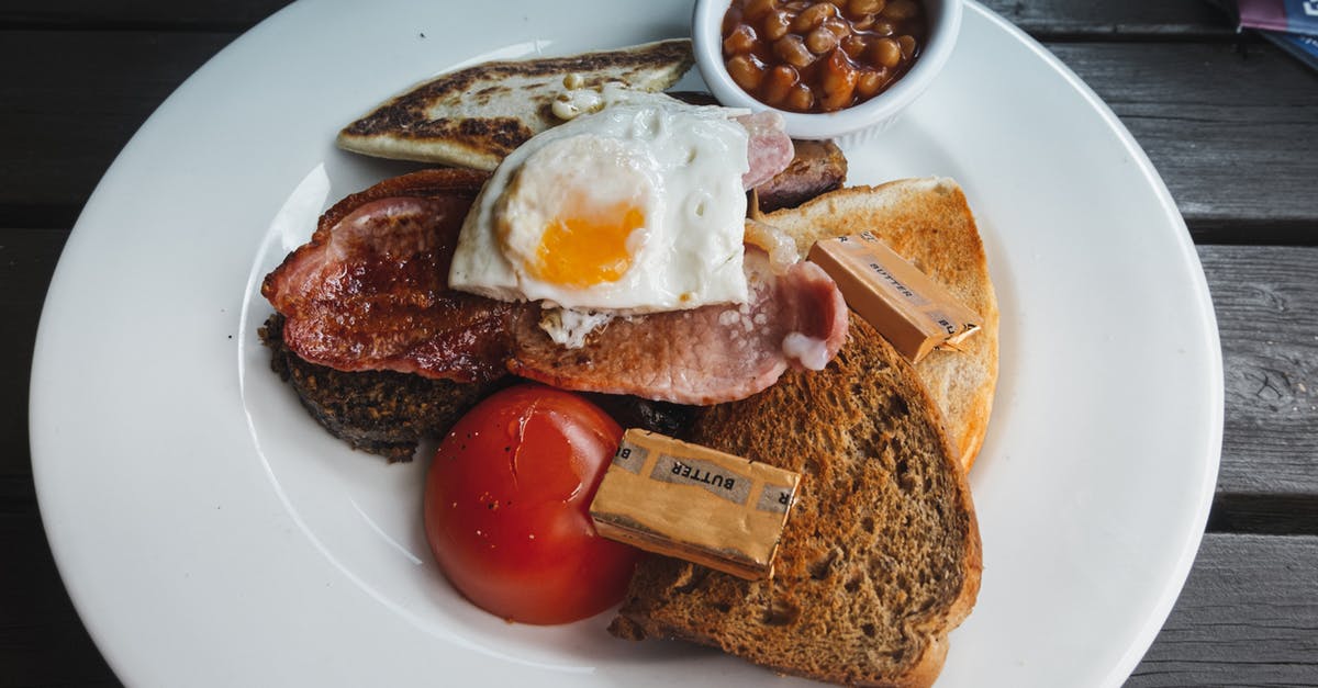 Alkaline tasting bacon - is it safe? - From above of toasted bread with fried bacon and egg served on white table with tomato and beans on wooden table