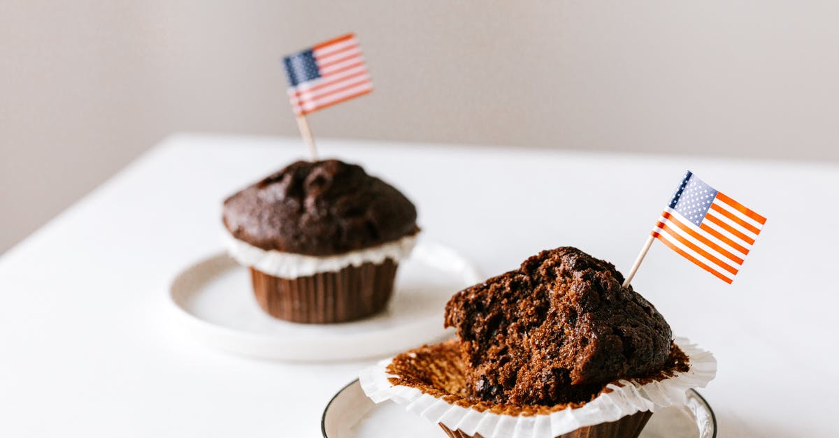 American equivalent for British chocolate terms - From above of bitten and whole festive chocolate cupcakes decorated with miniature american flags and placed on white table