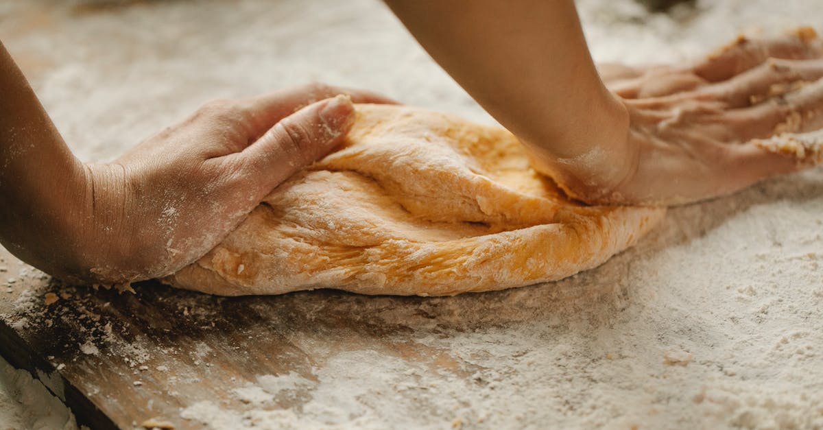 American pancakes: Why not substitute some wheat flour for starch? - Unrecognizable female kneading soft fresh egg dough on cutting board with flour in kitchen