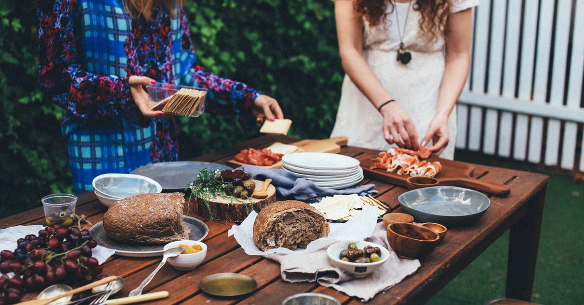 Amish Friendship Bread starter with buttermilk - Unrecognizable women serving table with assorted appetizers in garden