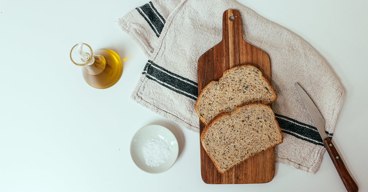 Amount of salt in bread - A Chopping Board on Towel with Slices of Bread Beside Olive Oil and Salt