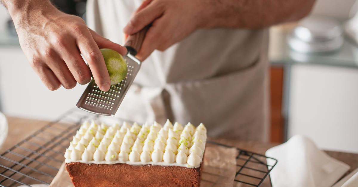 An efficient way to zest key limes? - Close-up of a Person Grating Lemon Zest over a Cake