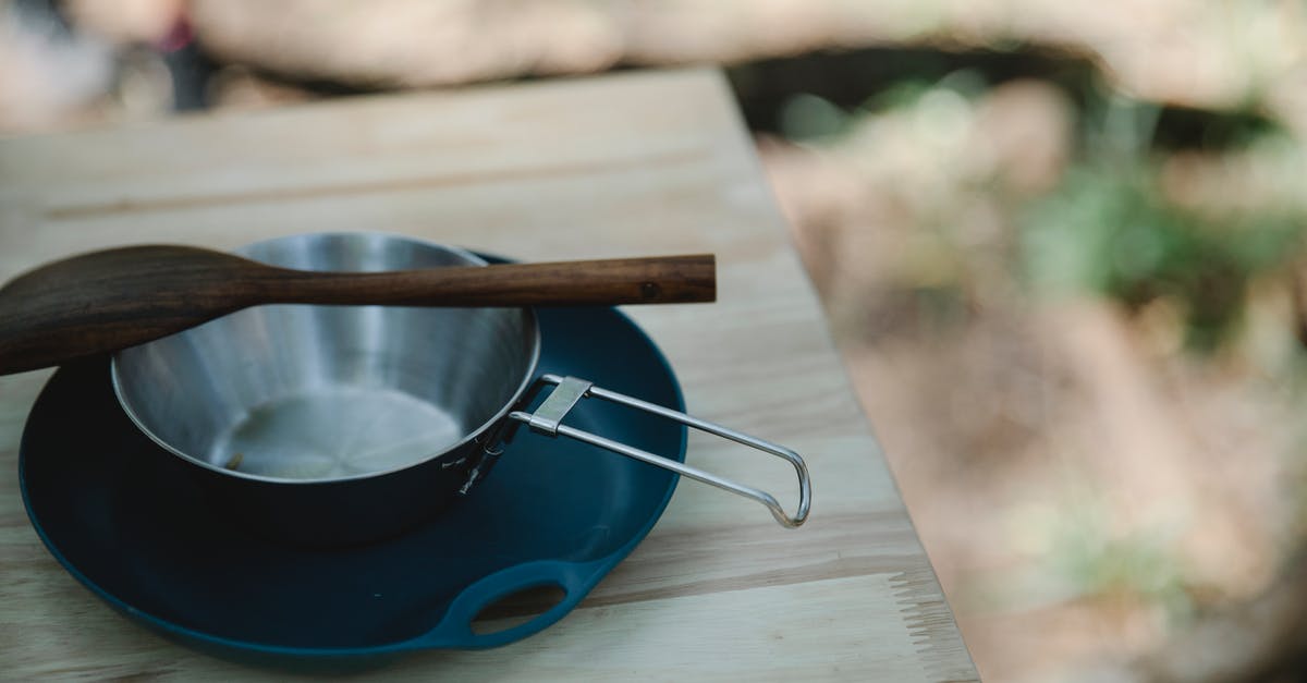 Anodized pans? Cleaning? - High angle of metal pan and wooden spatula placed on plastic plate on table