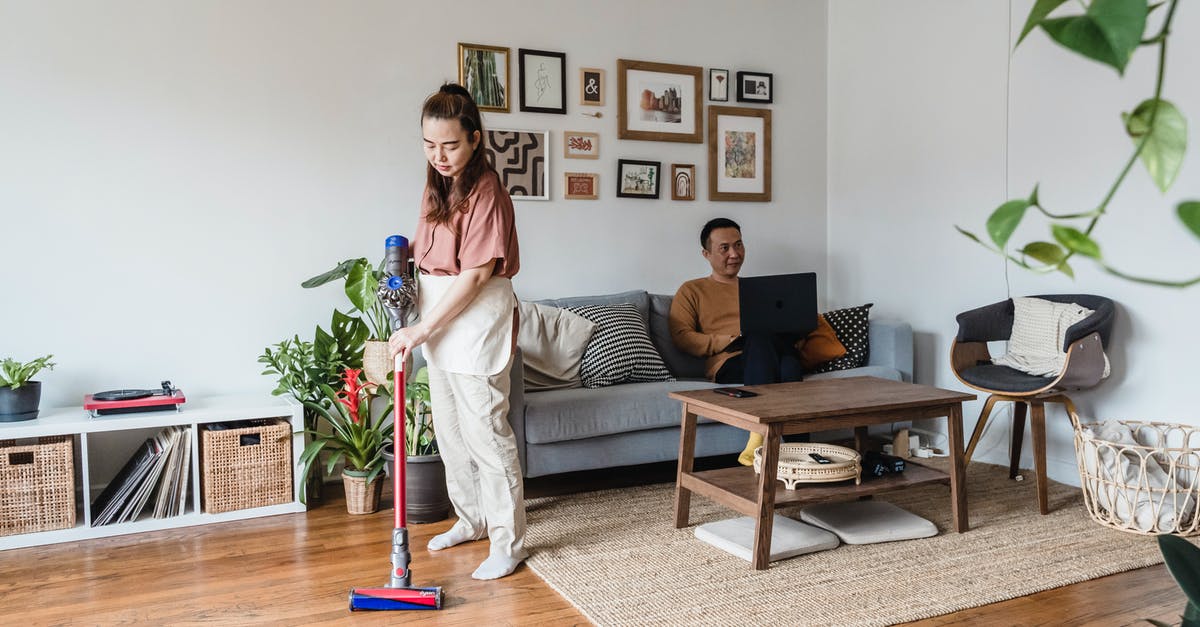 Anodized pans? Cleaning? - A Man Working from Home and a Woman Vacuuming in a Living Room