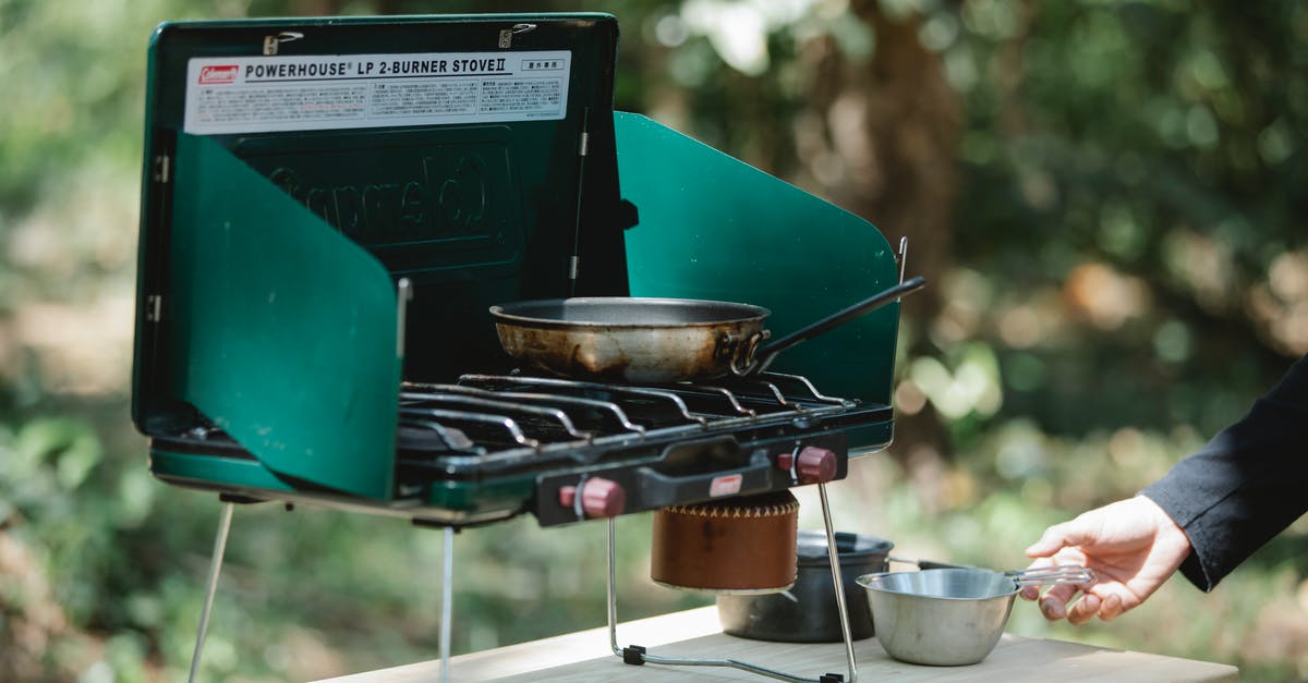 Any fix for a warped carbon steel fry pan? [duplicate] - Crop man cooking on metal stove in nature