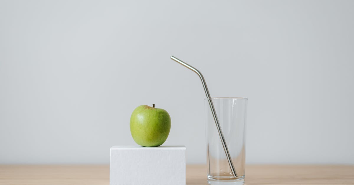 Apple pie: peel or not? - Green apple on box near empty glass with straw