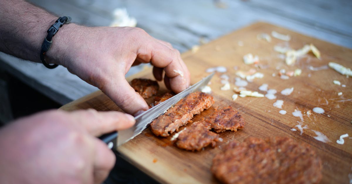 Arby's Roast Beef - what cut of meat? - Crop anonymous male cook cutting yummy grilled cutlet on wooden board before serving