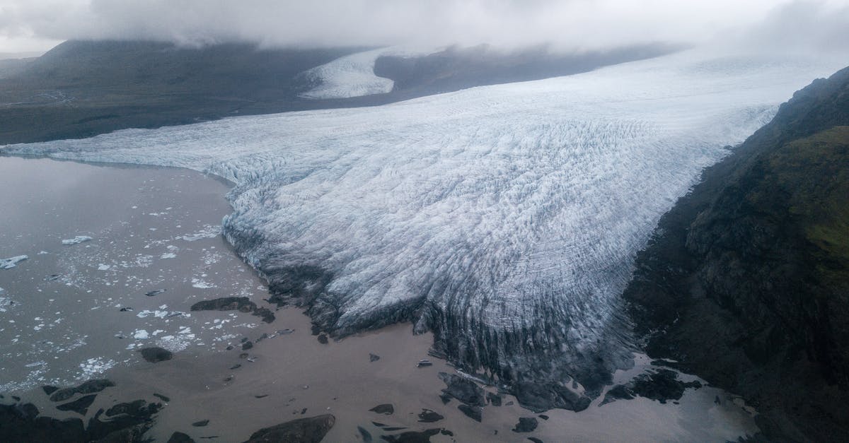 Arctic char available in North-America - Majestic glacier tongue reaching seashore under gloomy misty sky