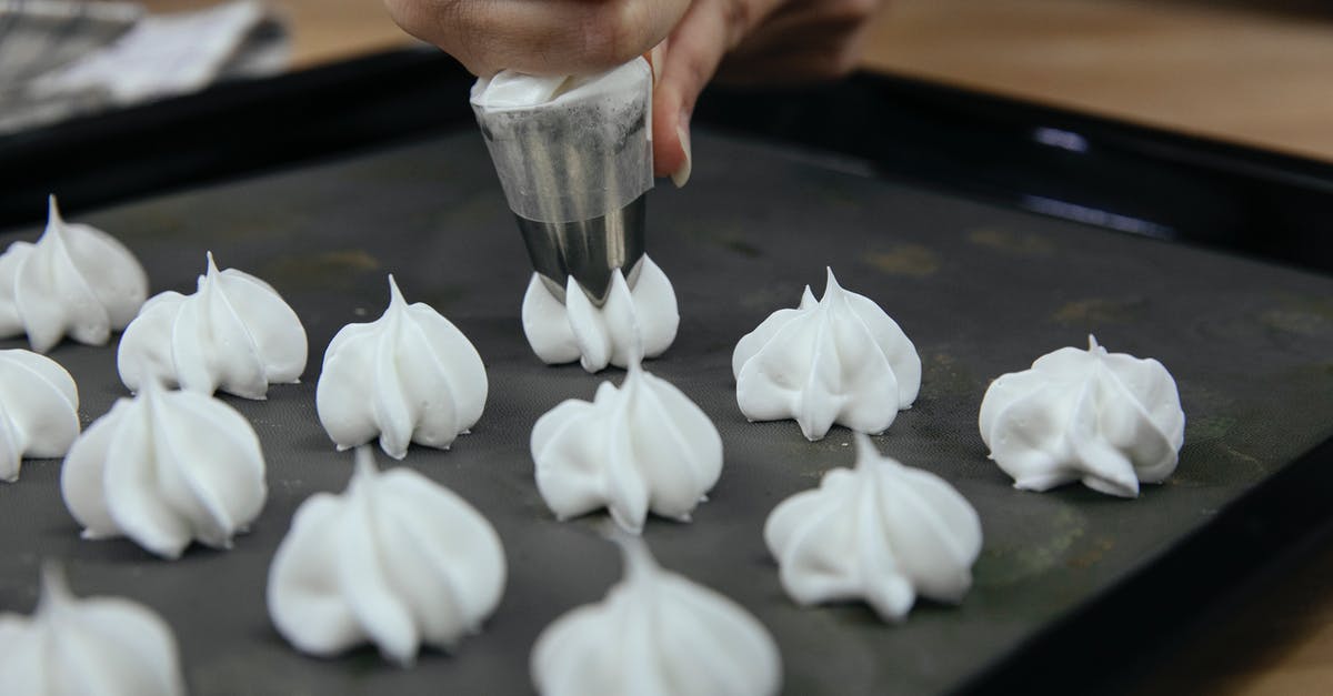 Are egg whites generally available at the store? - Crop anonymous cook putting out meringue from pastry bag onto baking tray during cooking process