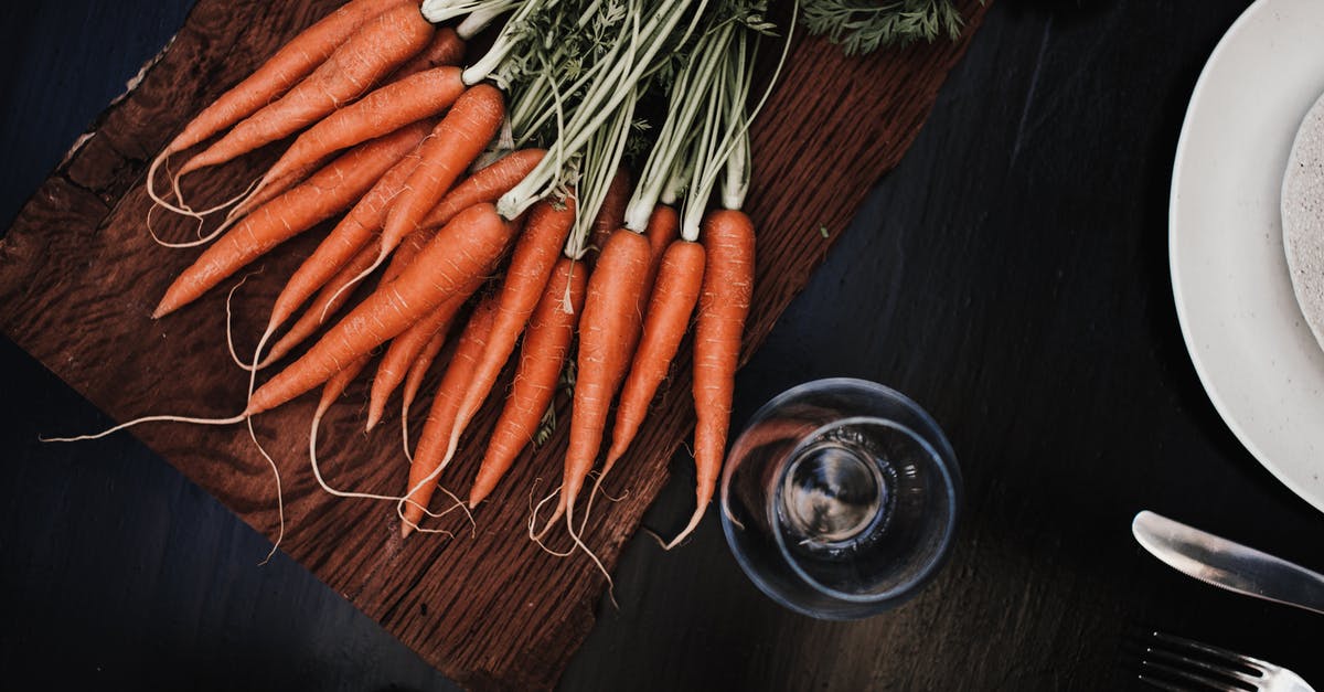 Are Gem Squash Edible After the Green Rind Turns Yellow/Orange? - Top view of ripe carrots placed on timber board near glass and plate with knife and fork