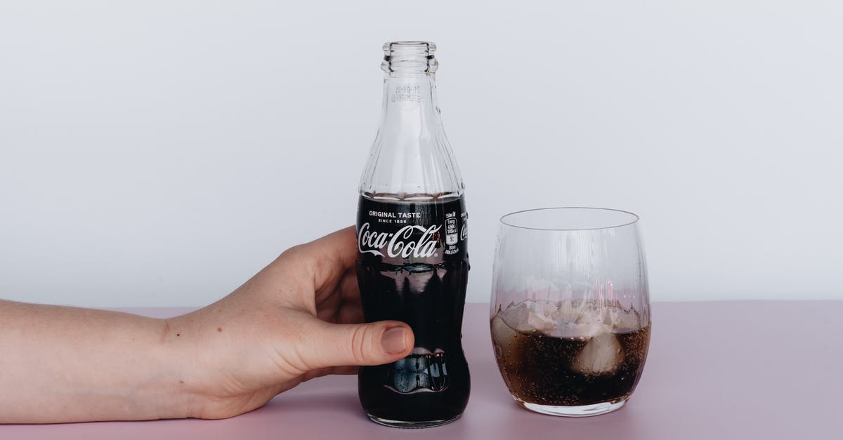 Are ice tea in bottles considered as carbonated drinks like coke? - Photo Of Person Holding Bottled Soft Drinks