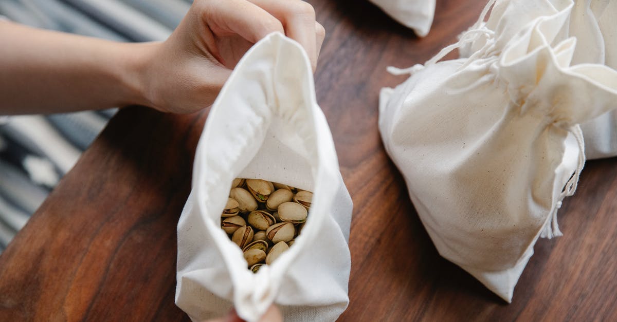 Are "shelled nuts" with or without their shells? - Faceless person demonstrating recycling bag with pistachios