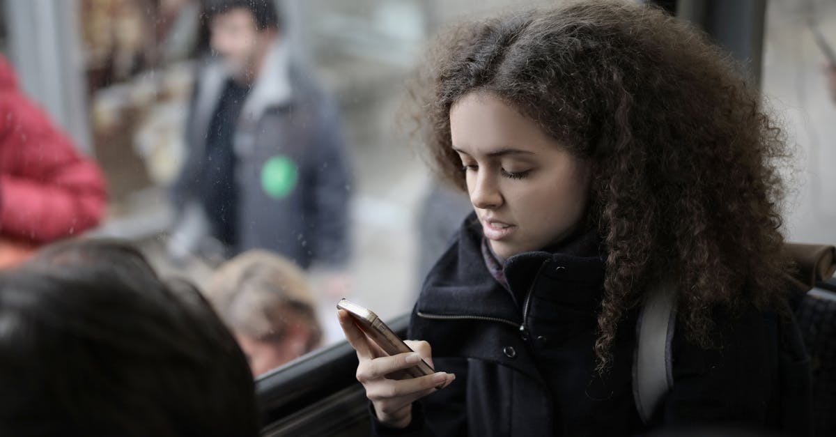 Are residues from seasoning coating harmful when using carbon steel pan? - From above view of serious young female traveler with backpack sitting on passenger seat in bus near window and browsing smartphone