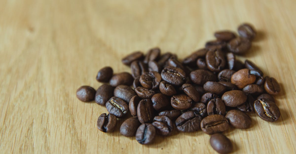 Are roasted bean flours edible as is? - Closeup of handful of prepared coffee beans scattered on table before making coffee