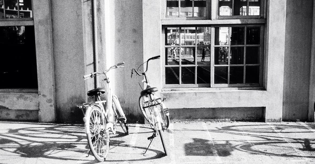 Are stone or metal grinding wheels better for flour? - Bicycles parked on sidewalk near concrete building