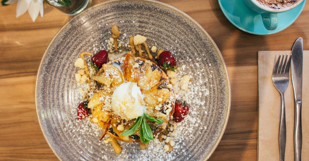 are syrup more flavorful than powder or similar? - Top view plate with yummy ice cream on pancakes topped with nuts and strawberries served on wooden table with cup of aromatic hot cappuccino