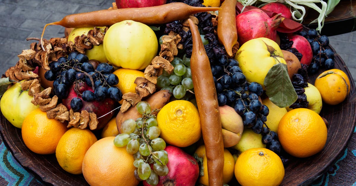 Are there any cons to heating orange and grape juice? - Assorted ripe healthy fruits composed with traditional Georgian sweets