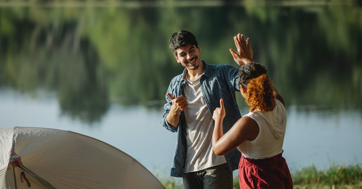 Are there any other brands like Xtrema? - Glad male hiker with unrecognizable ethnic female beloved showing thumbs up and giving high five while looking at each other in campsite