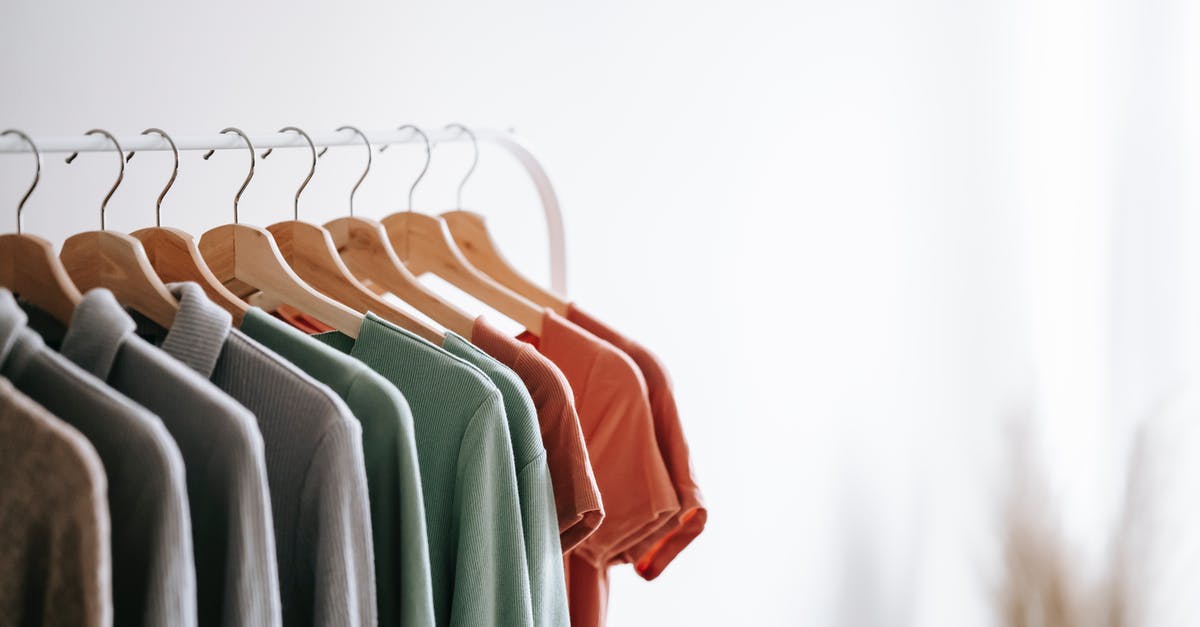 Are there different grades or styles of bacon? - Interior of light apartment with different clothes on wooden hangers in wardrobe near white walls